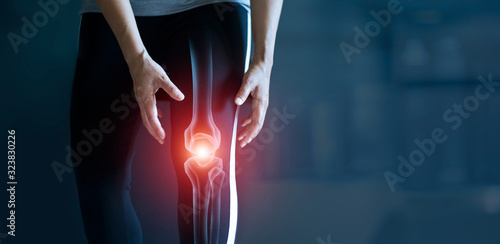 Woman suffering from pain in knee, Injury from workout and osteoarthritis, Tendon problems and Joint inflammation on dark background.