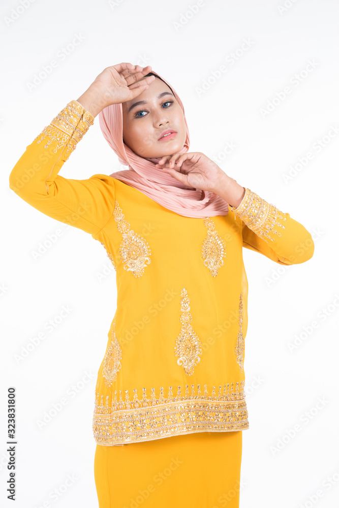 Obraz premium Beautiful female Muslim model in modern kurung and hijab, a modern lifestyle apparel for Muslim women isolated on white background. Beauty and hijab fashion concept. Full length portrait