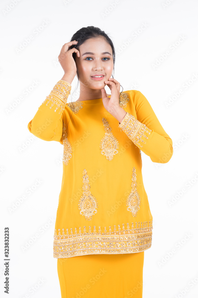 Beautiful female Asian model in various poses wearing modern kurung, a Malaysian traditional wear isolated on white background. Beauty and fashion concept. Half length portrait Beautiful female Asian model in various poses wearing modern kurung, a Malaysian traditional wear isolated on white background. Beauty and fashion concept. Half length portrait