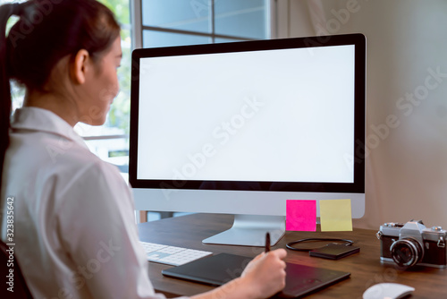 Asian women of happy smiling are using computer mockup of blank screen and working designer on the table office. Take your screen to put on advertising.