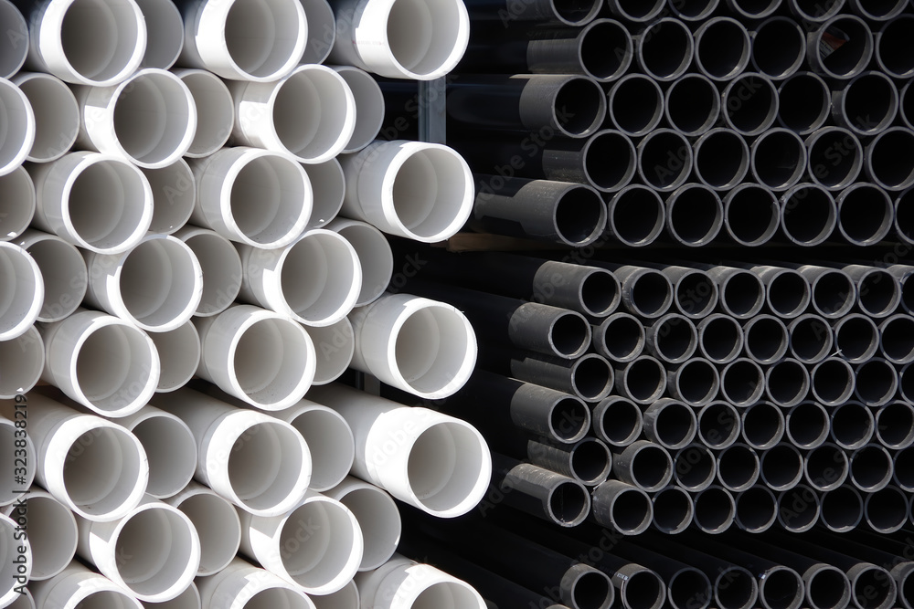 Close-up front view of stacks of black and white plastic water pipes Close-up front view of stacks of black and white plastic water pipes
