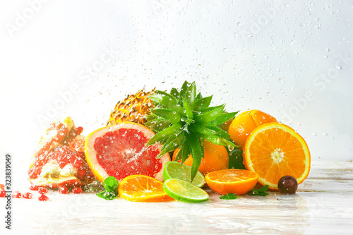 Fototapeta Naklejka Na Ścianę i Meble -  Fresh juicy fruits on a light ancient background under spray of water