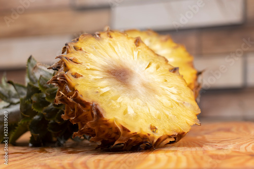 Ripe pineapple cut in two on a wooden cutting board