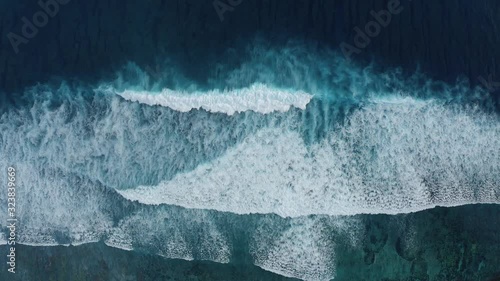 Slow-motion top down aerial view of the ocean giant waves, foaming and splashing