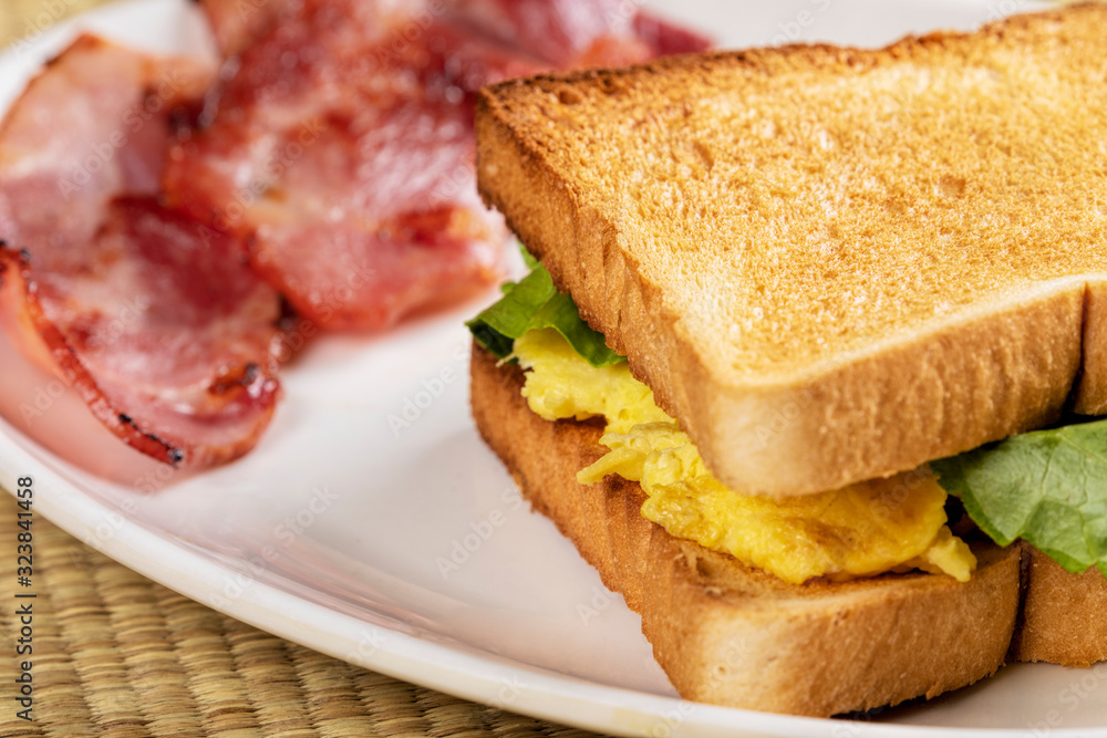 Delicious breakfast of scrambled eggs and toast with bacon Delicious breakfast of scrambled eggs and toast with bacon