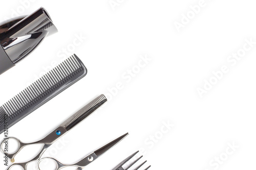 Hairdressing tools and hairdryer on white background, top view, copy space.