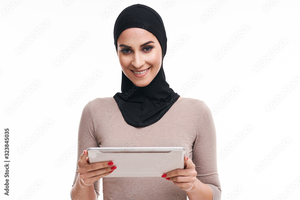 Muslim woman using tablet over white background Muslim woman using tablet over white background