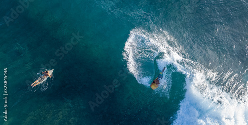 Tableau sur toile Surfers in the ocean, top to down aerial shot