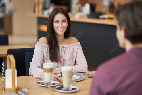 Young Couple Enjoying Coffee And Cake In Cafe