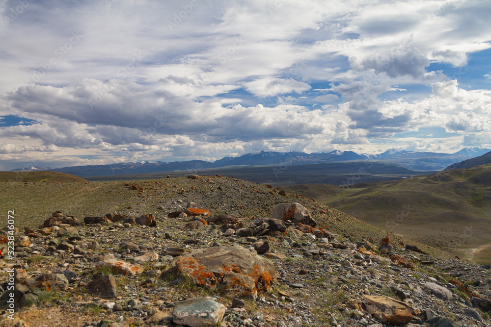 Panoramic view of a mountain valley summer, soft light, white clouds, blue sky. Altai mountains. Big rocks in front view. Panoramic view of a mountain valley summer, soft light, white clouds, blue sky. Altai mountains. Big rocks in front view.