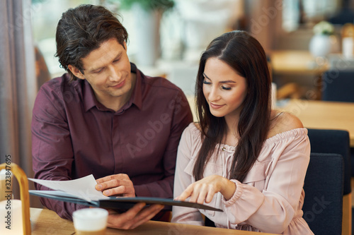 Young Couple looking at menu In Cafe