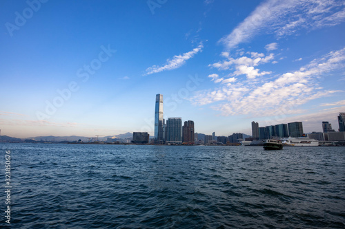Hong Kong, Victoria harbour. Skyscrapers on the shore, a boat and ferry float on the water