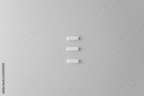 Scattered white oval pills for health. Concept of healthy lifestyle, vitamins taking.