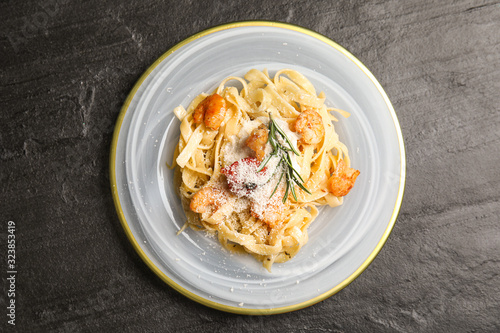 Delicious pasta with shrimps on black table, top view