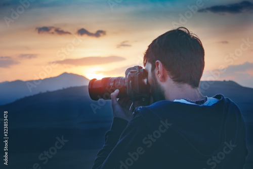 photographer photographs the sunset on the mountains