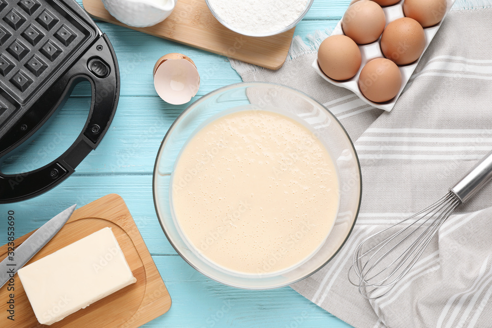 Flat lay composition with ingredients for cooking Belgian waffles on light blue wooden table Flat lay composition with ingredients for cooking Belgian waffles on light blue wooden table