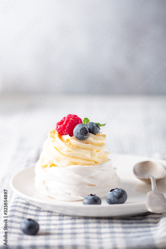 Delicious Pavlova cake with whipped cream and fresh berries on white plate. Scandinavian style. Soft focus Delicious Pavlova cake with whipped cream and fresh berries on white plate. Scandinavian style. Soft focus