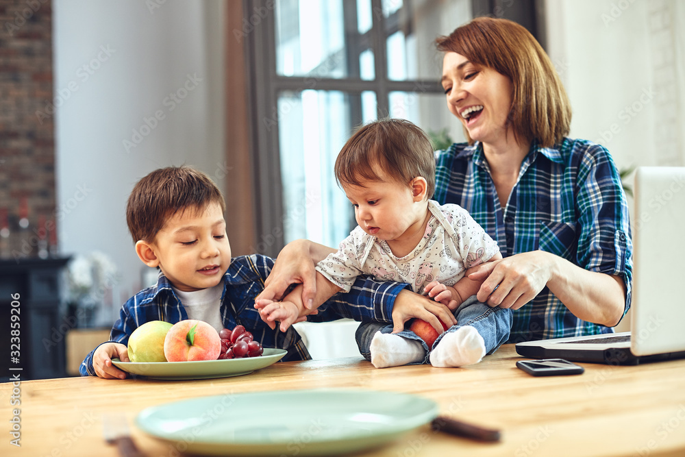 Fototapeta premium Happy international family concept. Dad, mom, son and little daughter posing for a camera at home, are engaged in home parenting. Home holidays, parenting, concept children and parents.