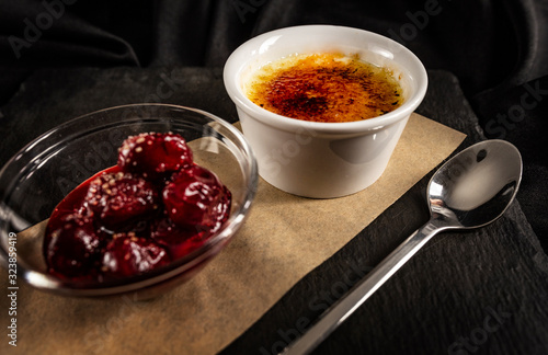 Close up of creme brulee, French vanilla cream dessert with caramelised sugar on top, black background