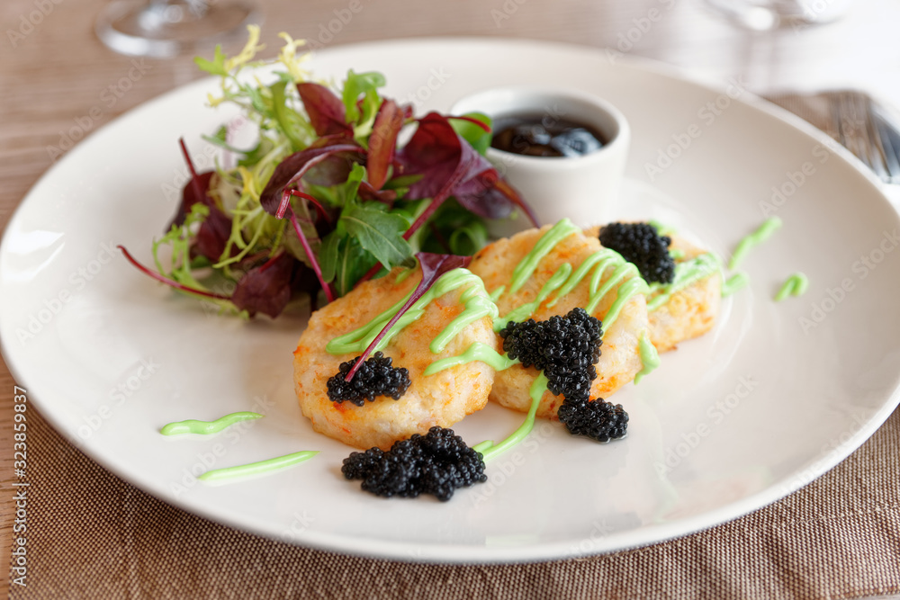 Crab cakes with salad mix, teriyaki sauce, seaweed caviar Crab cakes with salad mix, teriyaki sauce, seaweed caviar