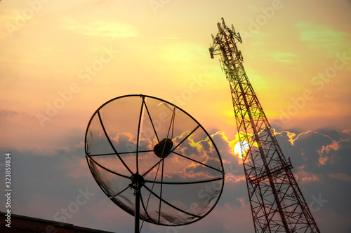 Fotografering Communications satellite dish and a telecommunications tower at the sunset