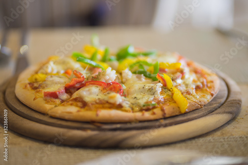 Seafood cheese pizza on plate pan with shrimp prawn sweet pepper capsicum on table