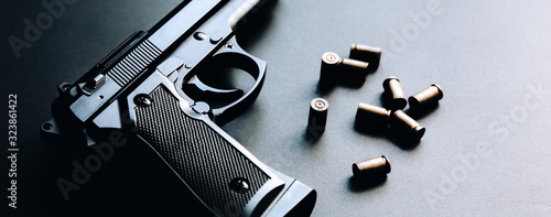 Canvas Print Gun with bullets lying on the table