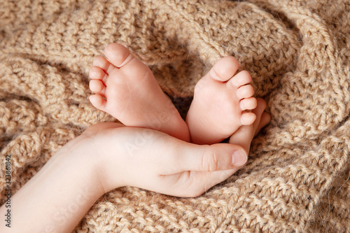 Baby feet in brother hands. Tiny Newborn Baby's feet closeup. Happy Family concept.