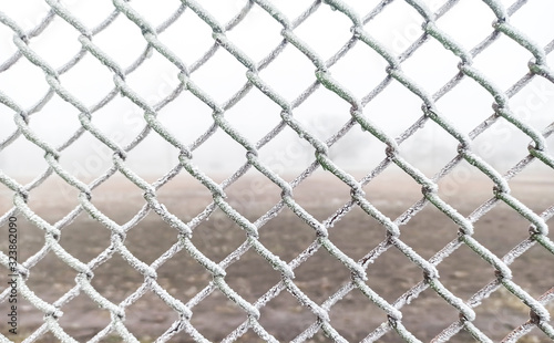 Frost on the net fence. Cold winter weather.