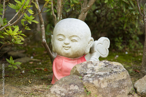 Photograph of a statue of a small angry Buddha with a red dress