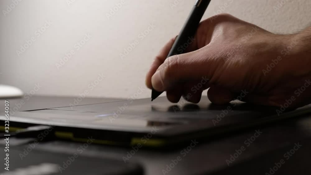Designer working with graphics tablet. Designer working on a graphic project on a graphics black tablet. Close up shot
