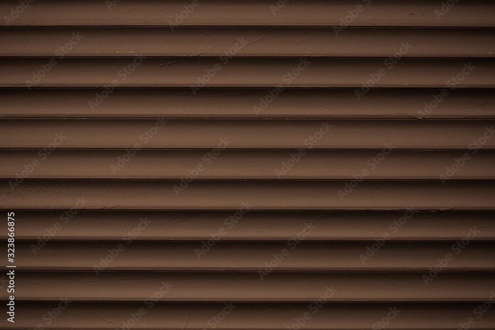 Metal striped pattern. Dark brown ribbed siding texture. Lines of fence, abstract grooved background. Metal striped pattern. Dark brown ribbed siding texture. Lines of fence, abstract grooved background.