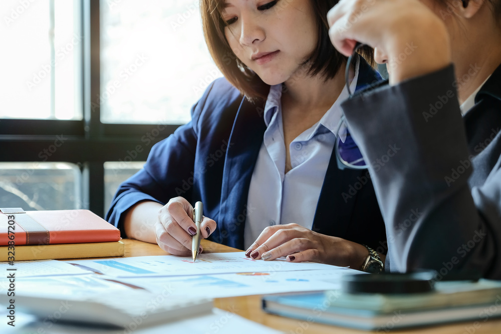 Group of businesswoman discussing on stockmarket charts in office Group of businesswoman discussing on stockmarket charts in office