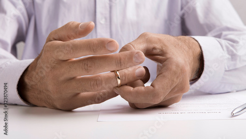 Man taking off wedding ring in lawyers office