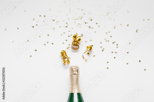 Bottle of champagne with glitter and confetti