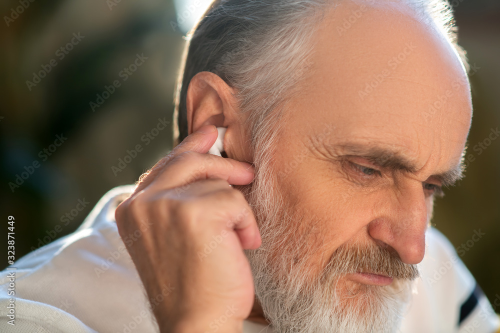 Obraz premium Close up picture of a man attaching wireless earphones