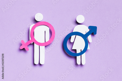 Cartoon woman and man with feminine and masculine signs on them