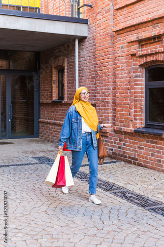 Sale and buying concept - Happy arab muslim girl with shopping bags after mall