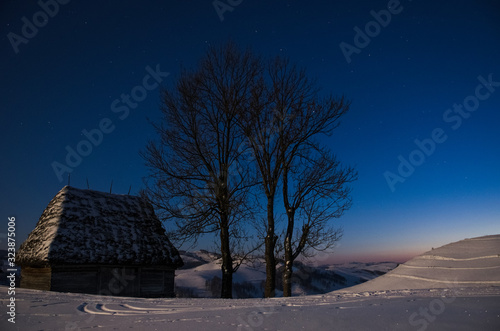 Night photography with traditional houses in Dumesti village, Apuseni Mountains, Romania, in winter