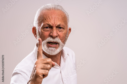 Portrait of angry senior man who threatens.