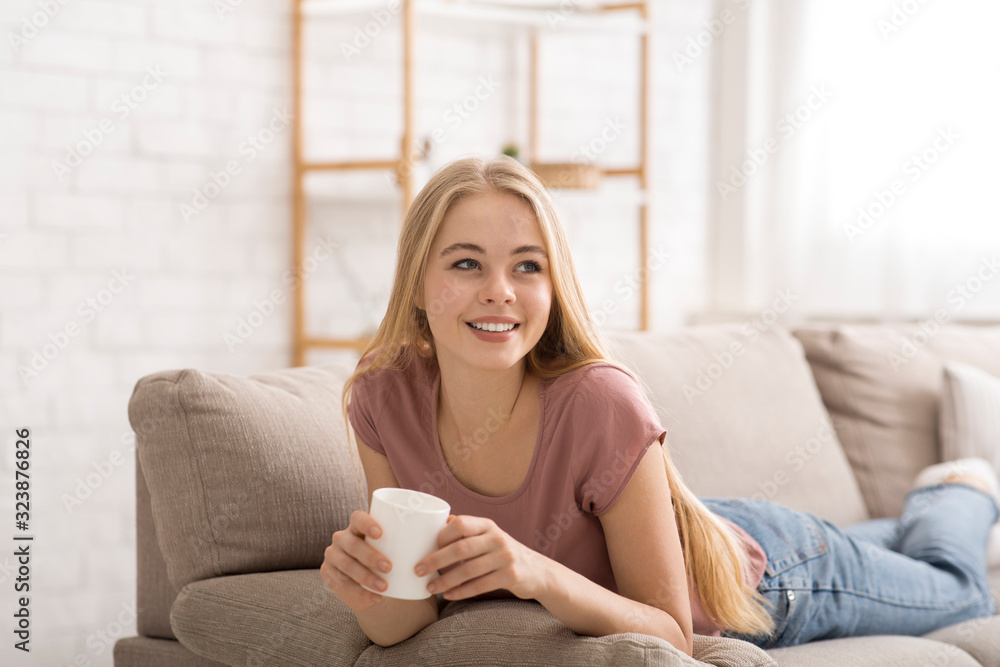 Cheerful blonde girl drinking tea at home Cheerful blonde girl drinking tea at home