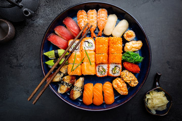 Gordijnen Sushi bar Sushi en maki bovenaanzicht zwart  © petrrgoskov
