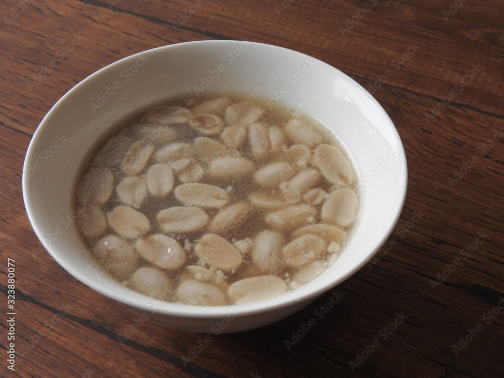 High angle view of a bowl of peanut soup isolated on wooden background. Peanut also called groundnut. With high oil content. Food, dessert and Taiwan agriculture concept. High angle view of a bowl of peanut soup isolated on wooden background. Peanut also called groundnut. With high oil content. Food, dessert and Taiwan agriculture concept.
