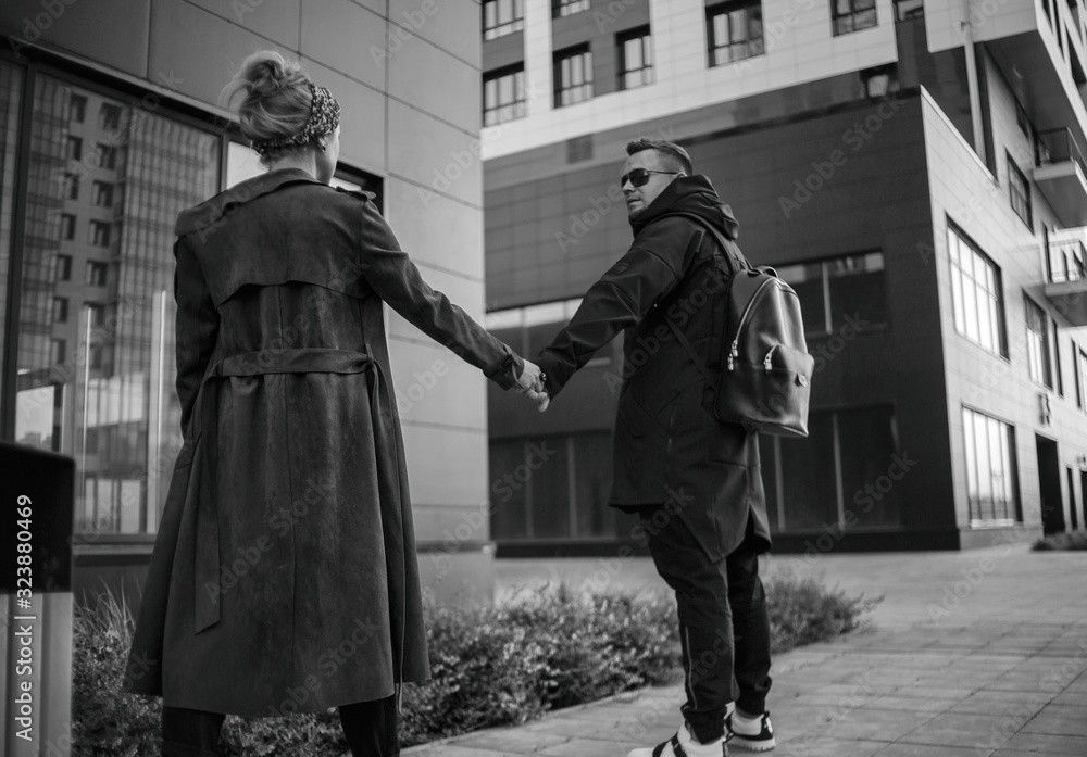 Beautiful couple in stylish clothes in gray tones. City. Urban. Black and white higt contrast photo. Monocrome