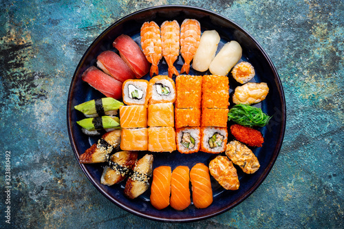 Set of sushi and maki with soy sauce over blue stone background. Top view with copy space photo