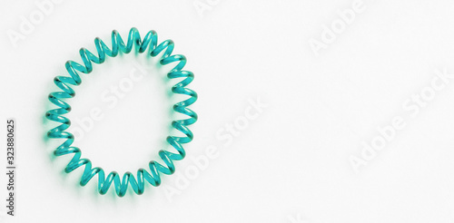 Aqua Menthe spiral rubber band. Elastic hair tie on white background close-up, copy space