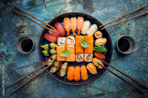 Obraz na płótnie Set of sushi and maki with soy sauce over blue stone background