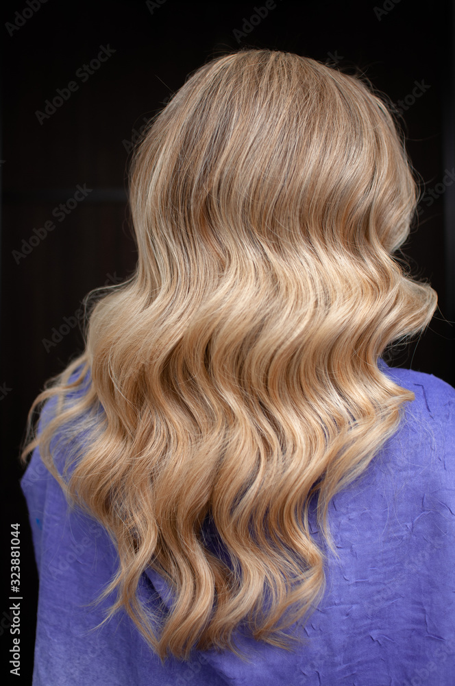 Naklejka premium Long hair of a blonde woman with wave hairstyle