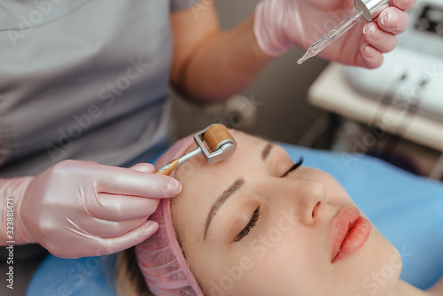 Beautiful girl woman in spa salon facial rejuvenation procedure.Visit a beautician.Hyaluronic acid rejuvenation beauty injections mesotherapy.Concept of mesotherapy.Cosmetology.Mezoroller mesotherapy 