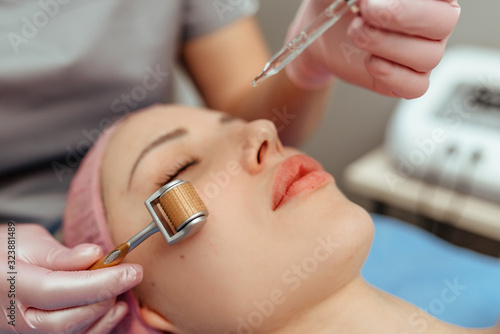Beautiful girl woman in spa salon,facial rejuvenation procedure.Visit a beautician.Hyaluronic acid rejuvenation beauty injections mesotherapy.Concept of mesotherapy.Cosmetology.Mezoroller,mesotherapy